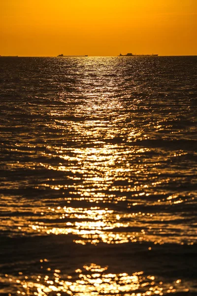 Barcos de carga en el horizonte en el sol poniente — Foto de Stock