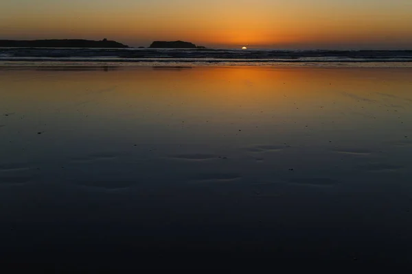 Мокрый песок во время отлива на фоне заката — стоковое фото
