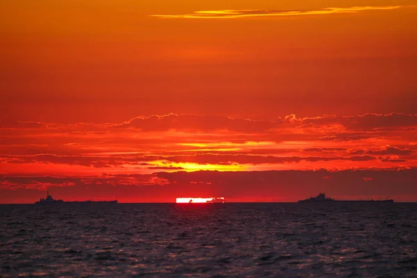 Navios mercantes no horizonte contra o pano de fundo de um incêndio — Fotografia de Stock