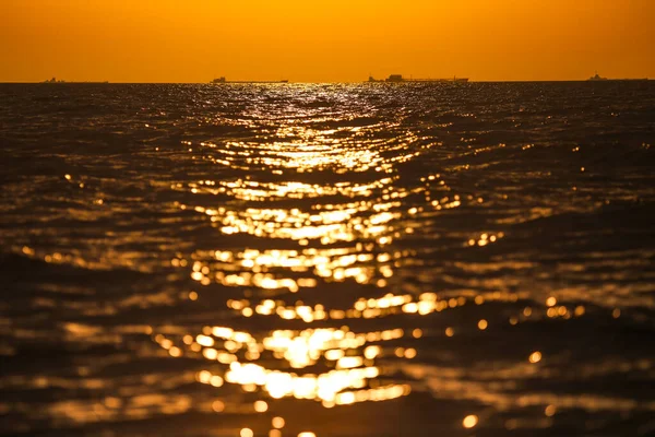 Barcos de carga en el horizonte en el sol poniente — Foto de Stock