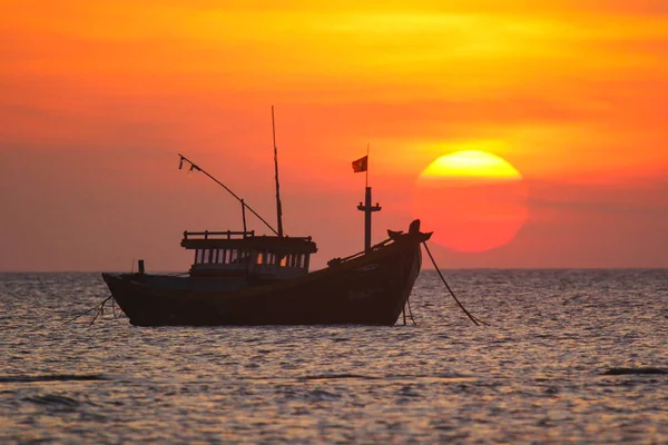 Fischerboot im Hintergrund eines riesigen Sonnenuntergangs — Stockfoto