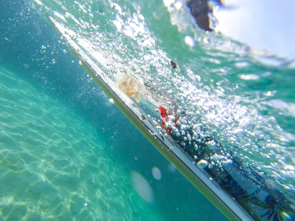 Girl on a surfboard on an ocean wave underwater — 스톡 사진