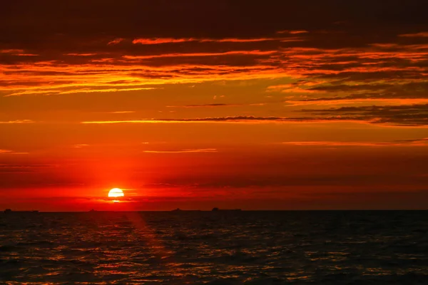 Handelsschiffe am Horizont vor dem Hintergrund eines feurigen — Stockfoto