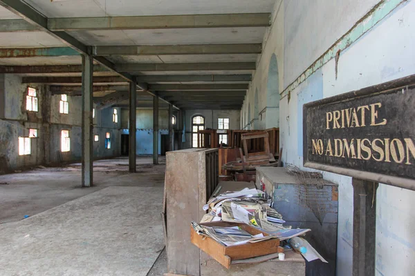 La oficina abandonada con una montaña de basura vieja con el cartel — Foto de Stock