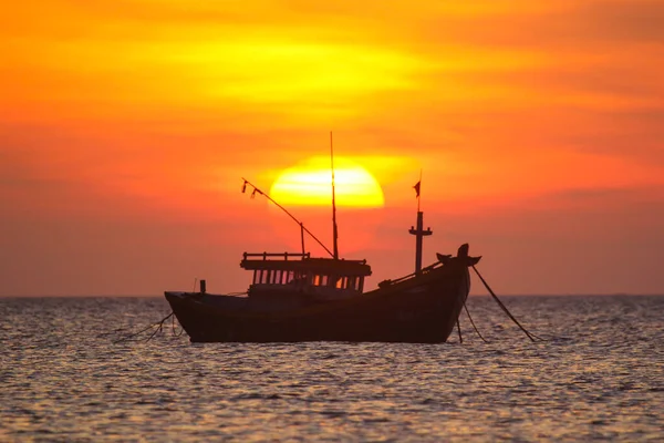 Fischerboot im Hintergrund eines riesigen Sonnenuntergangs — Stockfoto