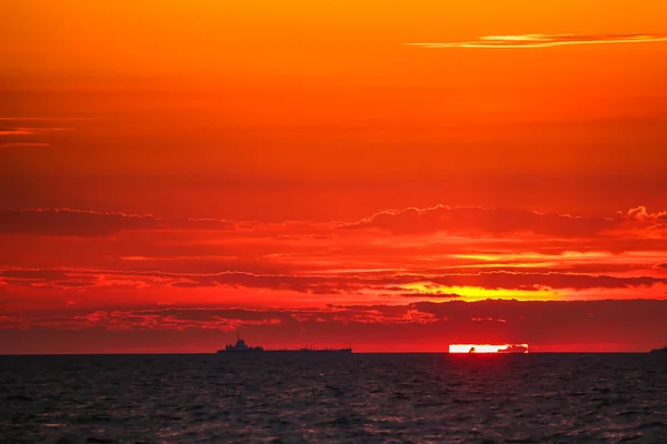 Navios mercantes no horizonte contra o pano de fundo de um incêndio — Fotografia de Stock