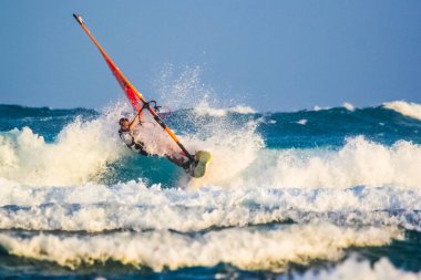 Okyanusun berrak dalgalarında sörf yapan rüzgar sörfü dalgaları