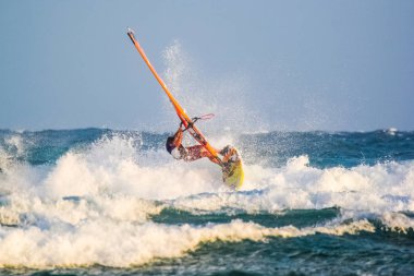Okyanusun berrak dalgalarında sörf yapan rüzgar sörfü dalgaları