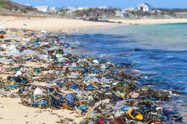 Plastik çöplerle dolu kumlu bir sahil manzarası. Okyanuslardaki ekolojik çöp sorunu
