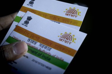 Hindistan 'ın Aadhaar kartı kimliği siyah arka planda seçici bir odak ile el ele tutuştu