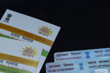 aadhaar and PAN cards of India linking on black background clipart