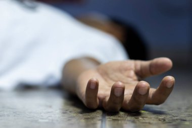COVID-19 ya da korona virüsü salgını sırasında yerde yatan Hintli ya da Asyalı bir kişi seçici odaklanma ya da sığ alan derinliği ile ölü bulundu.