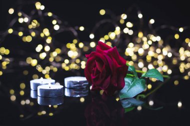 Sevgililer Günü geçmişi. Hediyeler, kırmızı gül, konfeti, siyah arka planda kalp şeklinde bokeh ışıkları olan zarf. Sevgililer Günü konsepti. Düz konum, ön görünüm, seçici odak, kopyalama alanı