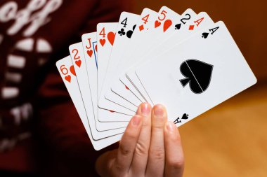 Poker kartlarını tutan ve gösteren biri.
