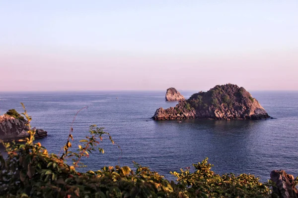 Akşamın erken saatlerinde Kuzey Vietnam 'da bulunan Halong Körfezi, kıpkırmızı güneşin yumuşak ışınlarıyla doludur. Maymun adasının tepesinden manzara inanılmaz..