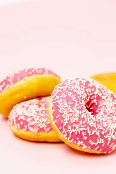 Четыре Пончика Розовой Глазури Белыми Брызгами Розовом Фоне Свитки Десерты — стоковое фото