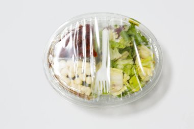 Daha az plastik kullan! Plastik ambalajdaki yiyecekler beyaz zeminde izole edilmiş. Gıda endüstrisi tarafından yapılan çevre kirliliğinin sembolü