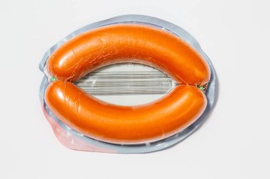 Daha az plastik kullan! Beyaz zeminde izole edilmiş plastik ambalajda domuz sosisi. Gıda endüstrisi tarafından yapılan çevre kirliliğinin sembolü