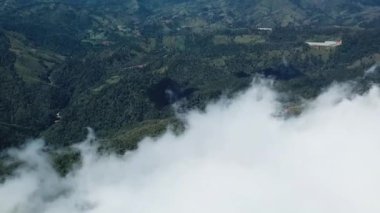 İnsansız hava aracı görüntüleri, jarabacoa Dominik Cumhuriyeti 'nde çok az nehre sahip tropikal dağların manzarasını göstererek beyaz bulutların üzerinde yavaşça uçuyor.