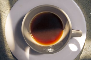 Beyaz kahve fincanı. Kırsal gri beton zemin üzerinde dramatik ışık ve zirve görüşü olan bir tabak veya tabak.