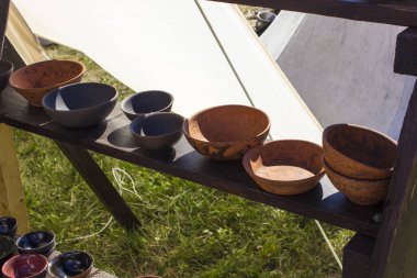 Ahşap bir rafta el yapımı çömlek, çevre dostu güvenli üretim.