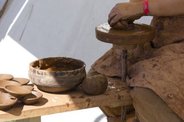 Kadın eski bir çömlek makinesinde çömlek yapıyor..