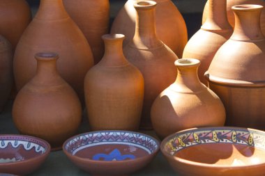 El yapımı kil tabaklar, sürahiler ve plakalar yakın plan, soyut arkaplan.