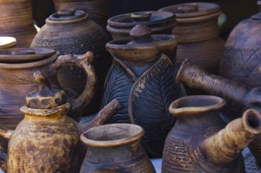 El yapımı kil tabaklar, yakın plan sürahiler, soyut arkaplan.