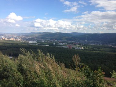 Kırsalda ağaçlarla kaplı yaz manzarası. Sibirya 'da sonbahar doğası. Bir hafta sonu ve berrak bir gökyüzü gerçek bir balıkçılık ve avcılık manzarası, dağlardan ağaçlarla dağlara. Plaj barbeküsü ve piknik alanı, tekne gezisi için bir göl.