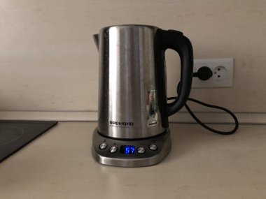 Termostatlı çaydanlık, telli çaydanlık, çay partisi, kaynar su, mutfak hikayeleri, şekerli çay. Bej bir mutfak takımında gri çaydanlık.. 