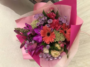 Sevdiklerinden ve sevdiklerinden bir buket çiçek, gözlerinde neşe ve mutluluk, aşkı, neşeyi ve mutluluğu hissetmek, endişelerden dinlenmek, güzel bir ambalaj kağıdı ve. Sıradan bir iş gününde ev yapımı bir çiçek buketi basit bir rüya neşesidir.