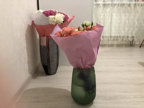 Bir buket gül. Pembe ve beyaz çiçekler. Bahar buketi. Kız arkadaşına hediye et. Bir kadın için çiçek seti. Yapraklı yeşil saplar. Kağıt üzerinde taze çiçekler ve bir vazo. Evdeki bitkiler. Beyaz ve parlak bir oda. Aşıklar günü. Sevgililer Günün kutlu olsun