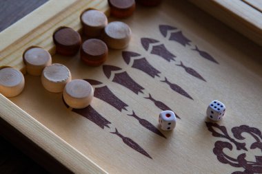 Tahtadan yapılmış tavla oyunu masanın üzerinde yatar..