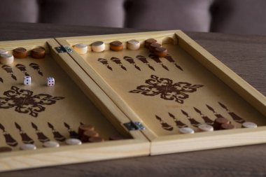 Tahtadan yapılmış tavla oyunu masanın üzerinde yatar..