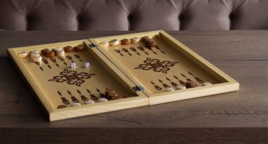 Tahtadan yapılmış tavla oyunu masanın üzerinde yatar..