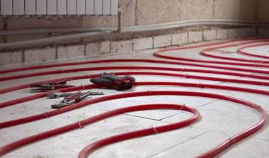 Evdeki ısı yalıtımlı zemin kırmızı bir polietilen boruyla döşenmiş..