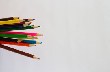 Beyaz arka planda çok renkli kalemler ve kalemler. Metin için okul malzemeleri..