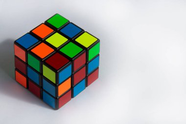 Beyaz arkaplanda gölgesi olan Rubik Küpü. Metin için kopyalanmış boşluk.