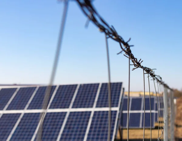 Güneşle yenilenebilir güneş enerjisi kullanan bir enerji santrali. Güneş panelleri dışarıda dikenli tellerin arkasında duruyor..