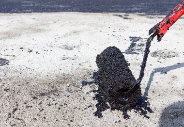 Beton yüzeyde bitümen, su geçirmez silindirli. Metin için yakın çekim. Kopyalama alanı