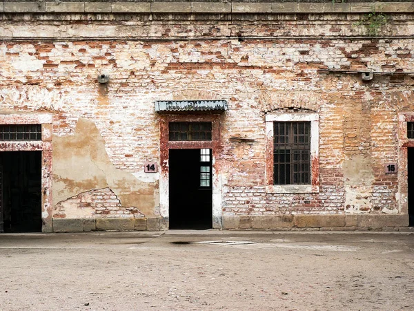 Кирпичный фасад с двумя дверями и окном с решетками — стоковое фото