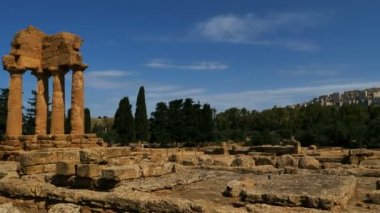 Agrigento, Tapınaklar Vadisi, Syracuse, Sicilya, İtalya. Castor ve Pollux Tapınağı 'nın kalıntıları. Arka planda modern şehir var..