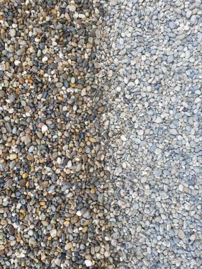 Renkli, yuvarlak ve ıslak çakıl taşları solda ve kuru çakıl taşları sağda rengin arka plan olarak tam olarak vurgulanmadığı yerde.