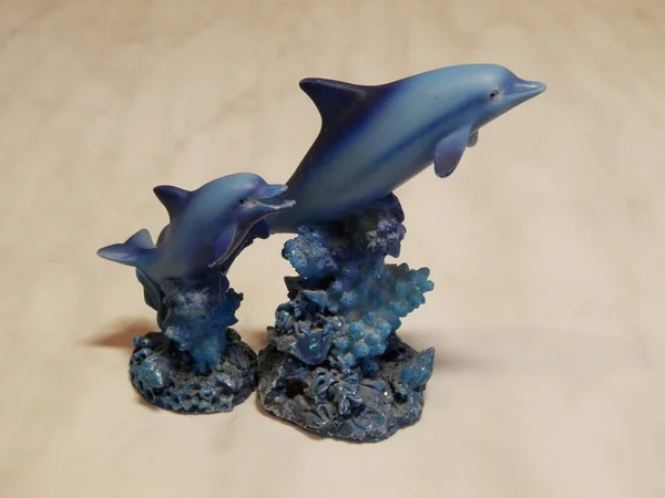 Figurines of two dolphins diving into the sea.