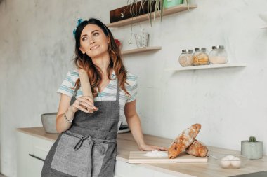 Ev hanımı mutfakta yemek pişiriyor.