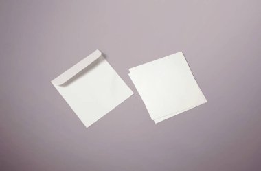 White envelope and post card on red background. Top view blank envelope mockup and blank letterhead presentation template. Empty sheet for your design.