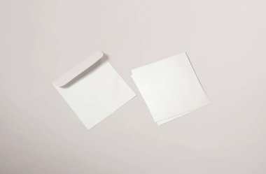 Beyaz zarf ve arka planda kartpostal. Üst görünüm boş zarf modeli ve boş antet sunum şablonu. Tasarımınız için boş sayfa.