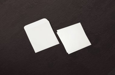 Beyaz zarf ve arka planda kartpostal. Üst görünüm boş zarf modeli ve boş antet sunum şablonu. Tasarımınız için boş sayfa.