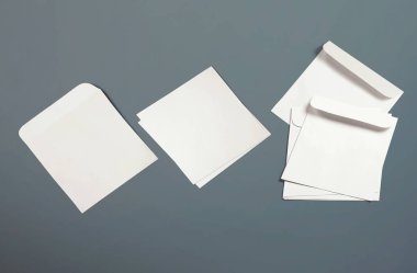 Beyaz zarflar ve arka planda kartpostallar. Üst görünüm boş zarf modeli ve boş antet sunum şablonu. Tasarımınız için boş sayfa.