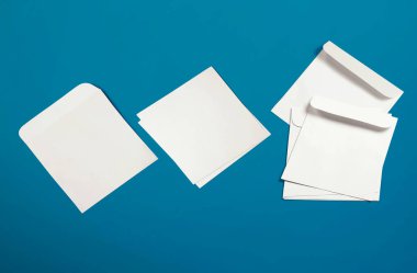 Beyaz zarflar ve arka planda kartpostallar. Üst görünüm boş zarf modeli ve boş antet sunum şablonu. Tasarımınız için boş sayfa.